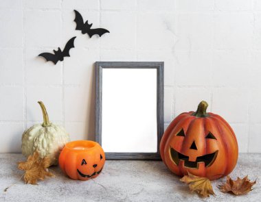 Jack o Lantern ve balkabağı dekoruyla çerçeveyi hazırla. Cadılar Bayramı konsepti Yarasalı beyaz bir duvara karşı poster çerçevesi.
