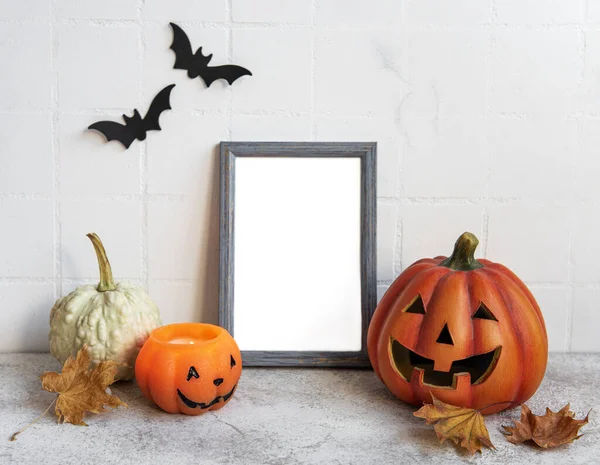 Jack o Lantern ve balkabağı dekoruyla çerçeveyi hazırla. Cadılar Bayramı konsepti Yarasalı beyaz bir duvara karşı poster çerçevesi.