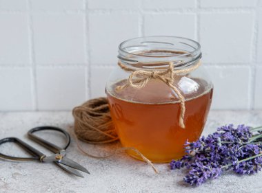 Ballı kavanoz ve çimento kaplı taze lavanta çiçekleri.