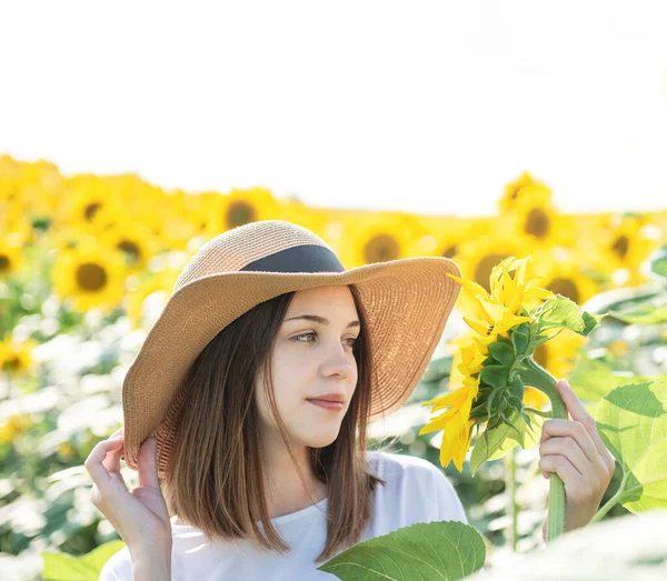 아름다운 소녀는 여름에 꽃피는 해바라기와 들판을 다닌다 — 스톡 사진