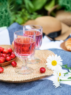 Lavanta tarlalarında piknik. Bardakta gül şarabı, battaniyede kiraz ve hasır şapka