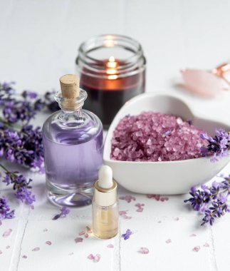 Lavanta kaplıcası. Temel yağlar, deniz tuzu, havlular ve mum. Lavanta çiçekli doğal bitki kozmetiği.