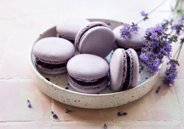 Fayanslı lavanta aromalı Fransız Makaronları ve taze lavanta çiçekleri.