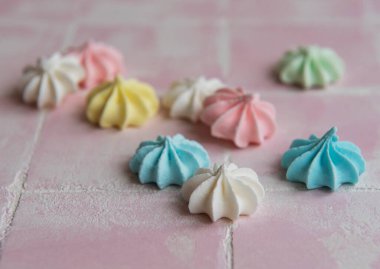 Pembe arka planda küçük renkli kremalar