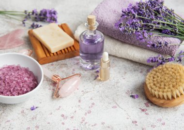Lavanta kaplıcası. Temel yağlar, deniz tuzu, havlular ve el yapımı sabun. Lavanta çiçekli doğal bitki kozmetiği.
