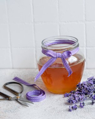 Ballı kavanoz ve çimento kaplı taze lavanta çiçekleri.