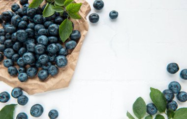 Beyaz fayans zemininde taze toplanmış yaban mersini. Sağlıklı beslenme kavramı