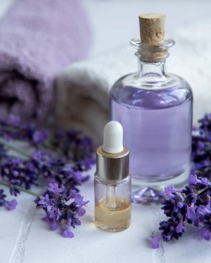 Lavanta kaplıcası. Gerekli yağlar, havlular ve lavanta çiçekleri. Lavanta çiçekli doğal bitki kozmetiği.