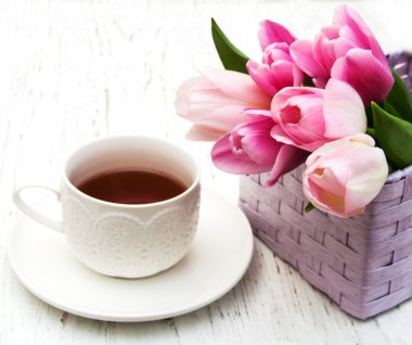 Fincan çay ve pembe laleler