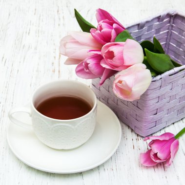 Fincan çay ve pembe laleler