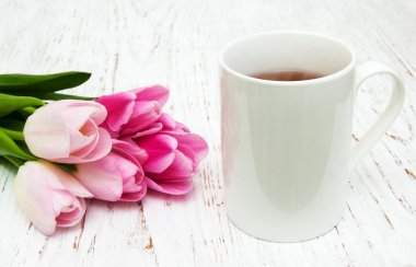 Fincan çay ve pembe laleler