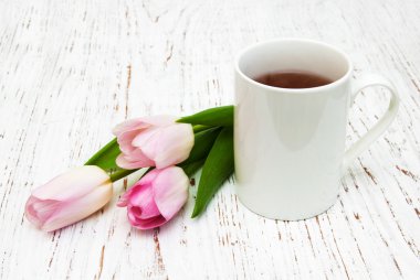 Fincan çay ve pembe laleler