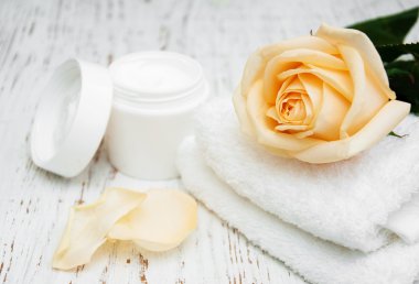Rose with moisturiser cream and towels clipart