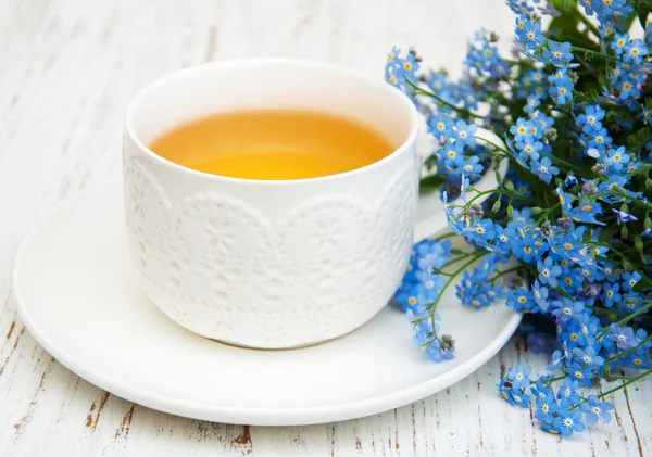 Cup of teand forget me not flowers — Stock Photo, Image