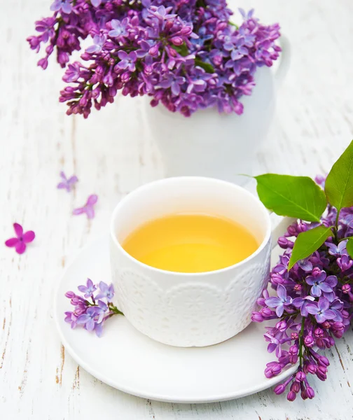 Cup of tea and lilac flowers Stock Picture