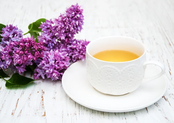 Tasse Tee und Fliederblüten — Stockfoto