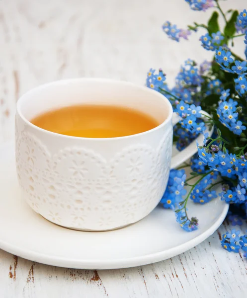 Cup of teand forget me not flowers — Stock Photo, Image