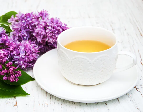 Cup of tea and lilac flowers — Stock Photo, Image