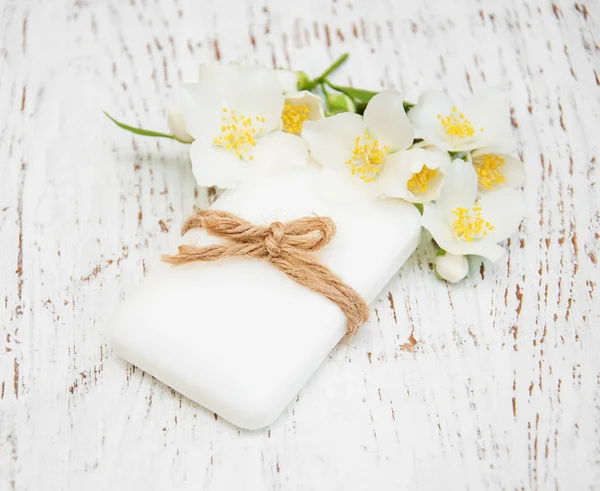 Jasmin flowers and soap on wooden table — Stock Photo, Image