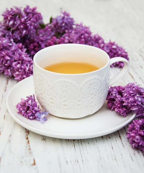 Cup of tea and lilac flowers — Stock Photo, Image