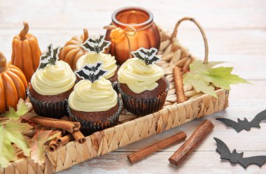 Cadılar bayramı partisi için krem peynirli ve yarasa süslemeli lezzetli çikolatalı kekler.