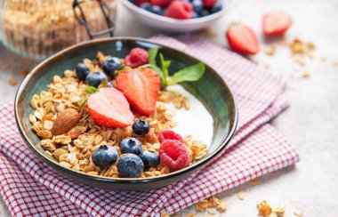 Kahvaltıya taze çilek, yabanmersini, ahududu ve badem ile hazırlanmış tahıl gevreği.