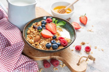 Granola with yogurt, strawberries, blueberries, raspberries, and almonds for a healthy start