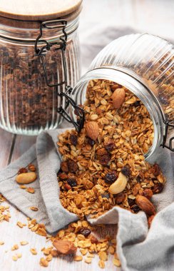 Kavanozdan dökülen lezzetli ev yapımı granola ile sağlıklı bir kahvaltı hazırlıyorum.