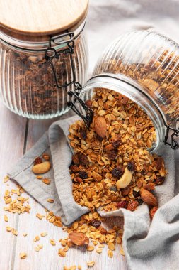 Kavanozdan dökülen lezzetli ev yapımı granola ile sağlıklı bir kahvaltı hazırlıyorum.