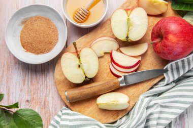 Fresh red apples, honey, cinnamon, and sugar preparing for a fall recipe
