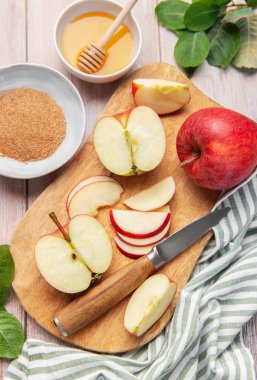 Fresh red apples, honey, cinnamon, and sugar preparing for a fall recipe