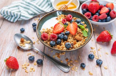 Granola, yogurt, strawberries, blueberries, and raspberries creating a nutritious breakfast