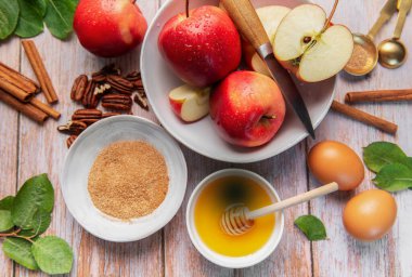 Fresh red apples, honey, cinnamon, and sugar preparing for a fall recipe
