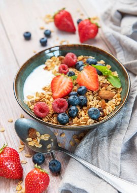 Sağlıklı bir kahvaltı için bir kase granola, yoğurt, çilek, yabanmersini, ahududu ve badem.