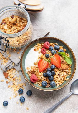 Yoğurtlu granola, yabanmersini, çilek ve ahududu sağlıklı bir kahvaltı sunar