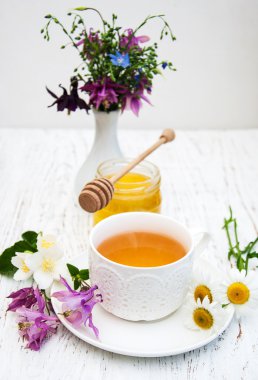 Fincan çay, bal ve çiçekler