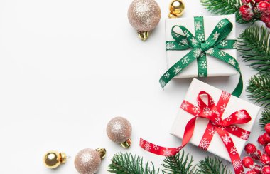 Hediye kutuları, süsler, kırmızı böğürtlenler ve beyaz arka planda köknar dalları olan tatil öğeleri