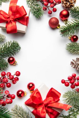 Noel süslemeleri ve hediye kutuları beyaz arka planda mevsimlik bir çerçeve oluşturuyor