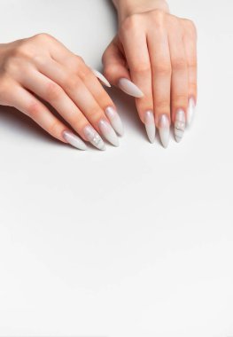 Kadın elleri zarif, uzun beyaz badem şekilli çivi şekilli çivi ve yapay elmaslar sergiliyor.