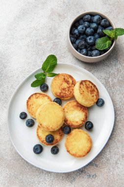 Lezzetli bir kahvaltı için taze yaban mersinli ve nane şekerli altın sarısı şuruplu börek.