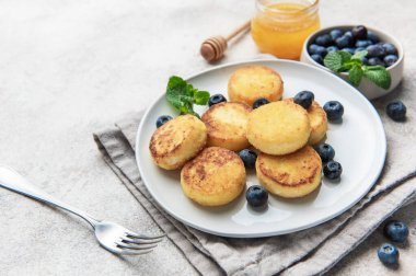 Ev yapımı Ukrayna şurubu taze yaban mersini, bal ve beyaz bir tabakta nane ile servis edilir.