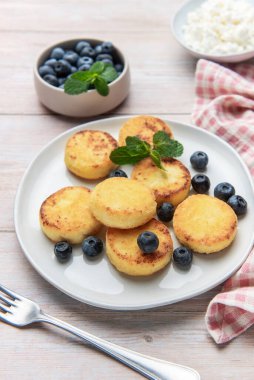 Lezzetli bir kahvaltı için böğürtlenli ve nane şekerli altın şuruplu krepler.