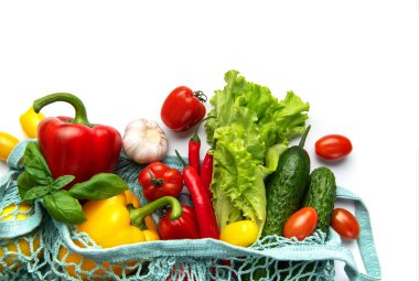 Ağdan dökülen dolmalık biber, marul ve domatesler dahil sağlıklı ürünler.