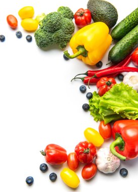 Beyaz arka planda taze sebze ve böğürtlenin renkli bir karışımı.