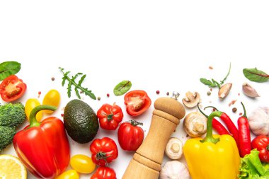 Taze sebzeler, otlar ve baharatlar beyaz arka planda canlı bir alt sınır oluşturuyorlar.