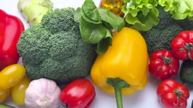 Beyaz bir yüzeyde ortaya çıkan renkli çiğ sebze seçimi sağlıklı bir besin gösterisi yaratıyor.