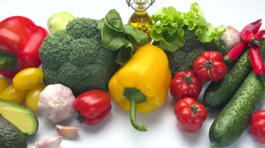 Colorful selection of fresh vegetables and olive oil for a healthy diet, isolated on white background