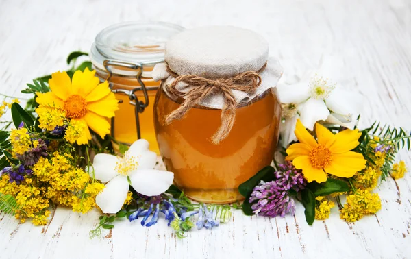 Μέλι και αγριολούλουδων σε ξύλινα φόντο — Φωτογραφία Αρχείου