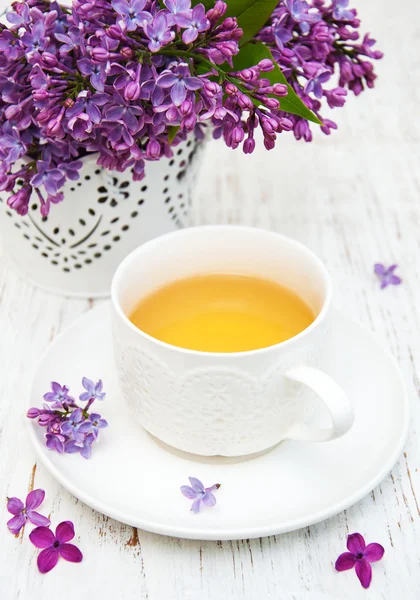 Cup of tea and lilac flowers — Stock Photo, Image