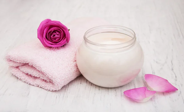 Crema esencial de spa con toallas y rosa — Foto de Stock